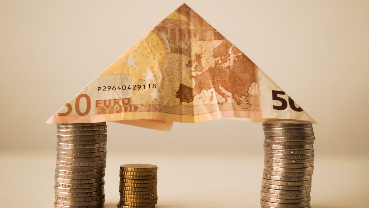 A creative composition using euro banknotes and coins to represent savings and financial structure.